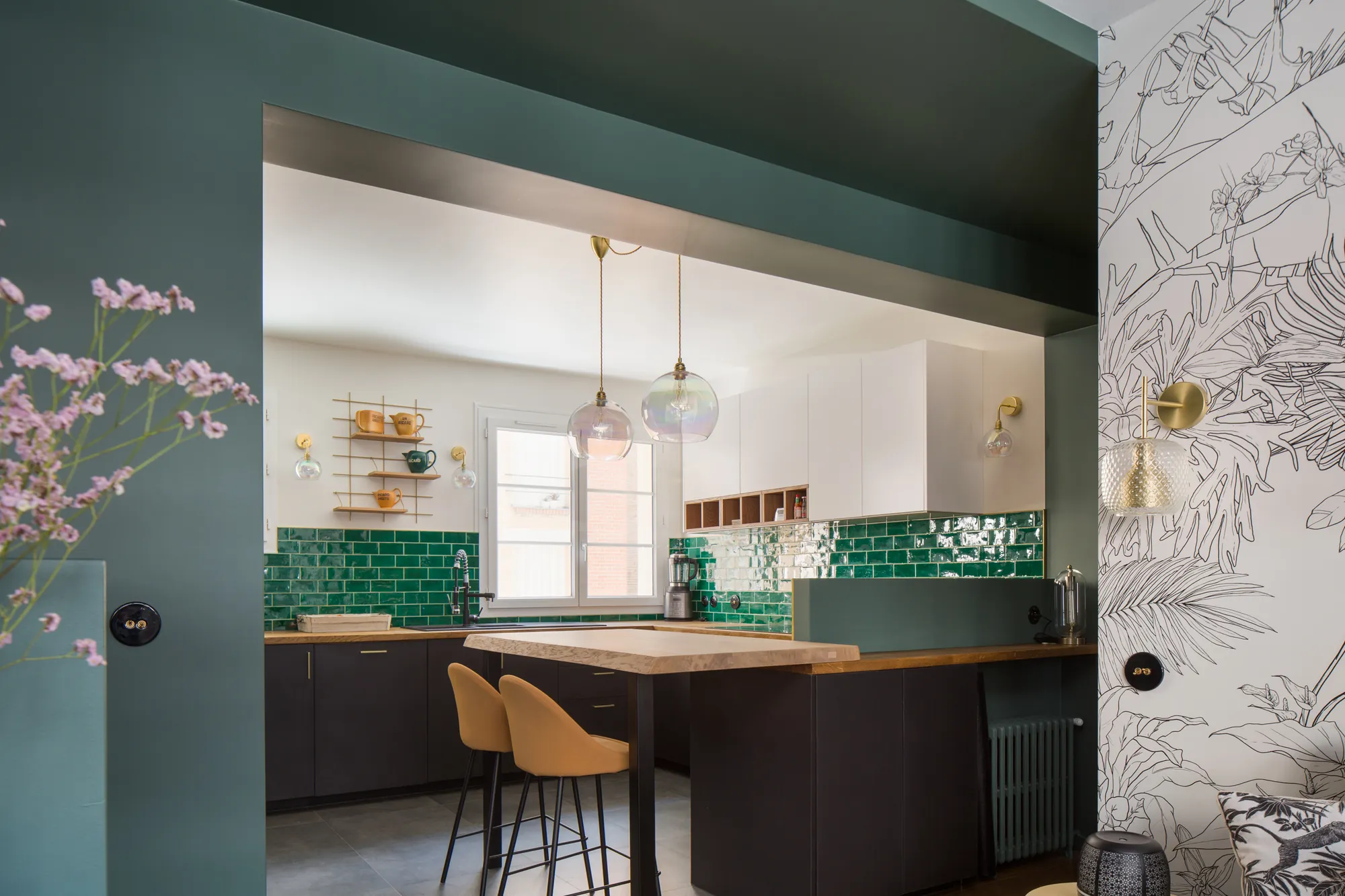 Cuisine ouverte sur la pièce de vie, crédence vert émeraude et îlot bois, appartement Paris 15e