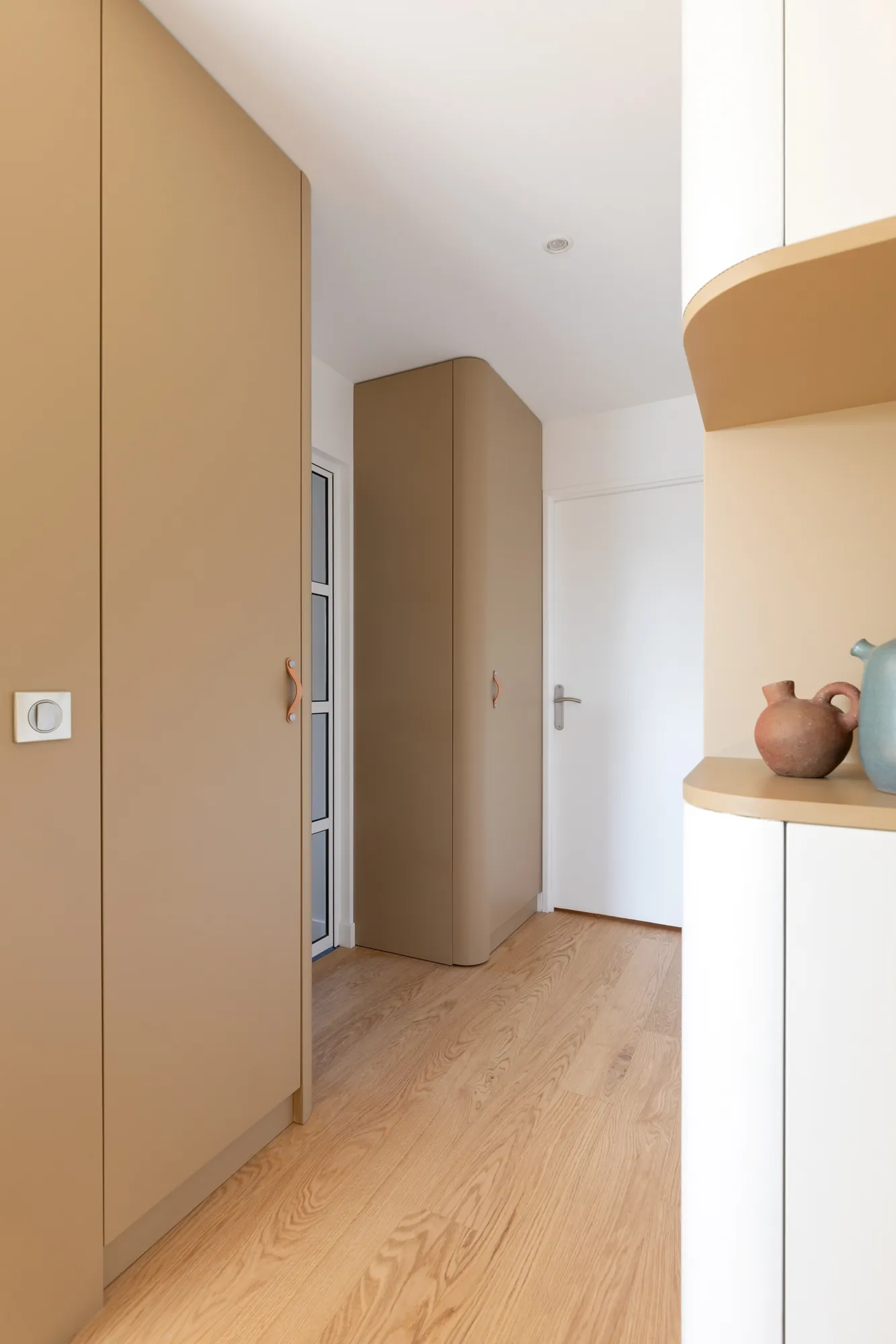 Menuiserie laquée caramel aux angles arrondis et étagère galbée, circulation de l'appartement Vanves