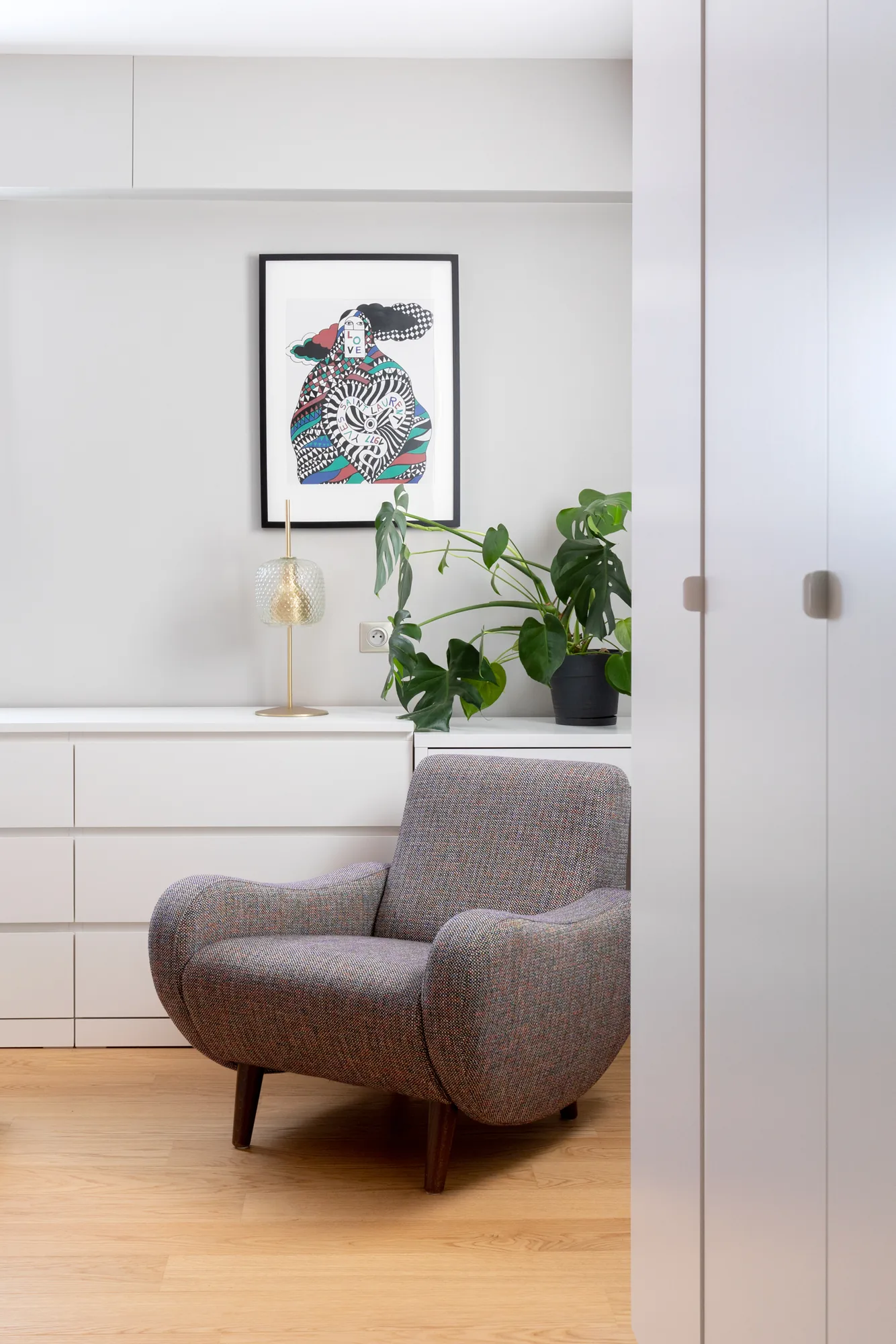 Fauteuil aux lignes épurées dans un coin de la chambre, lumière douce, appartement Vanves