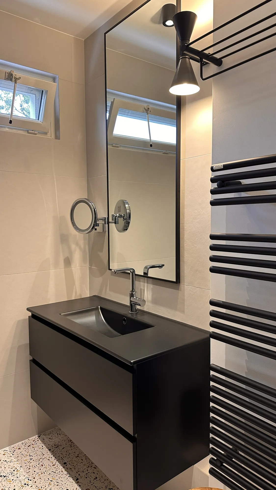 Salle de bain graphique et masculine, vasque et meuble noirs, sèche-serviette noir et sol terrazzo, appartement Garches