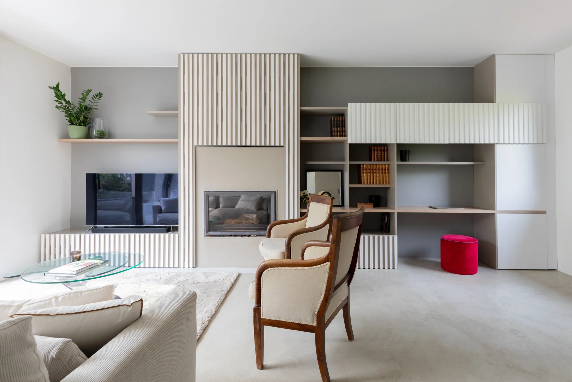 Mur en bois cannelé du séjour intégrant cheminée, bibliothèque et bureau, maison rénovée à Meudon